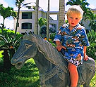 Davin rides a stone horse on the garden grounds