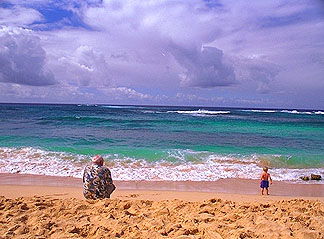 Grandfather and grandson relax on a wonderful beach in the Poipu area of Kauai